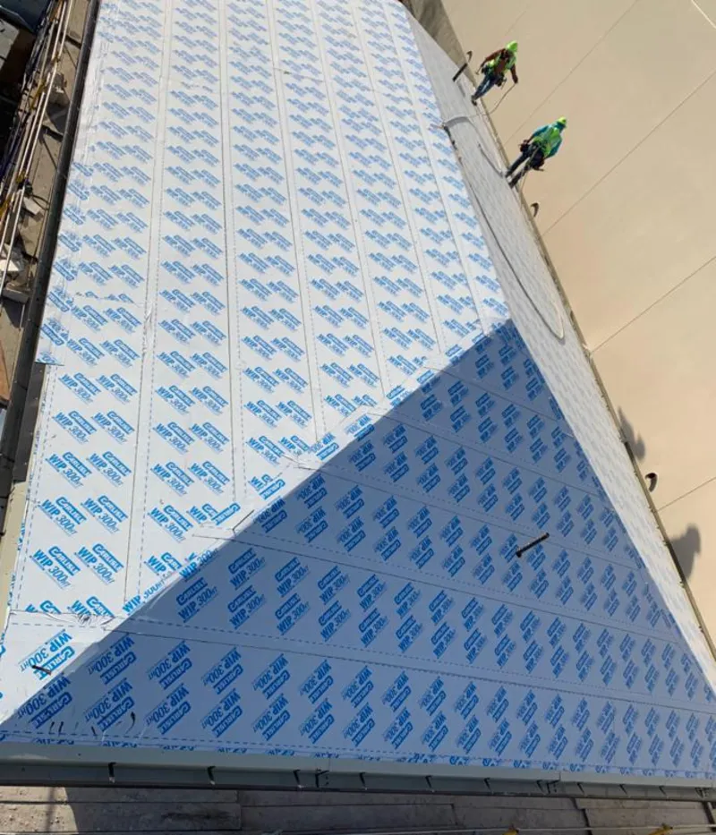 Professional roofers installing underlayment on a metal roof in Provo